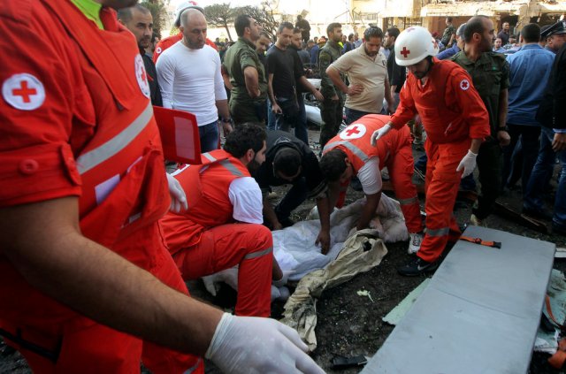 Red Cross personnel remove a body from the site of explosions near the Iranian embassy in Beirut